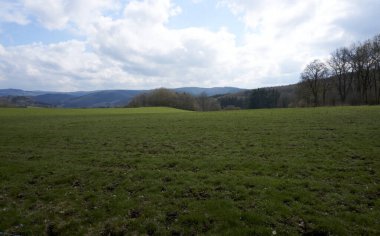 Almanya 'da bulutların, otların ve dağların manzarası, İlkbaharda Rhineland-Palatinate' de Vulkaneifel