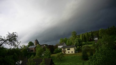 Baharda köyün üzerinde fırtına bulutları