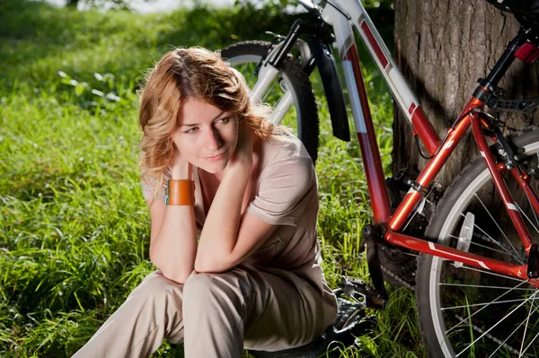Dziewczyna siedzi z rowerem — Zdjęcie stockowe