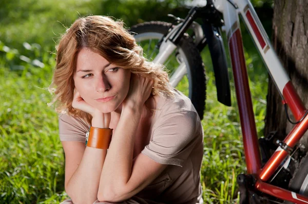 Ragazza si siede con una bicicletta — Foto Stock