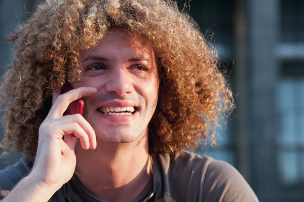 Jovem com cabelo encaracolado falar no celular — Fotografia de Stock