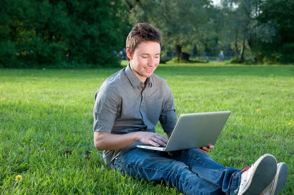 Man op het gras met laptop — Stockfoto