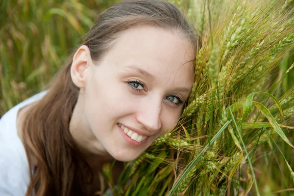 Mooie vrouw glimlacht in veld — Stockfoto