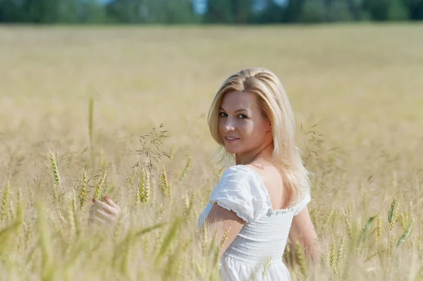 Beautiful woman smiles in field — Stock Photo, Image