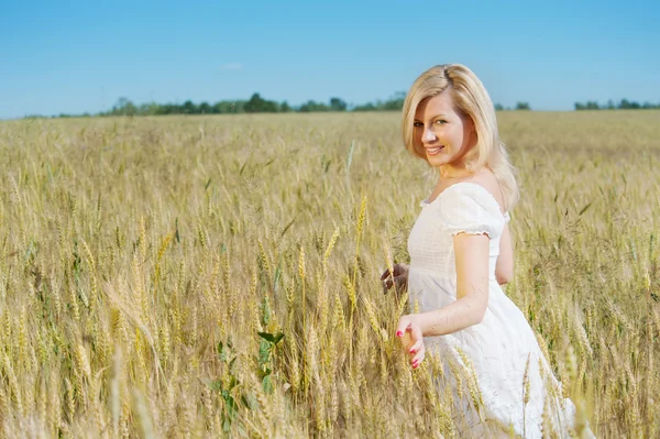 Beautiful woman smiles in a field — Stock Photo, Image