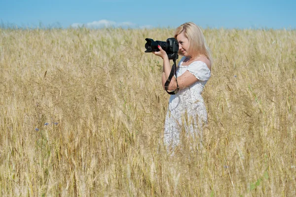 Güzel kadın bir alanda kamera ile fotoğraf çekmek — Stok fotoğraf