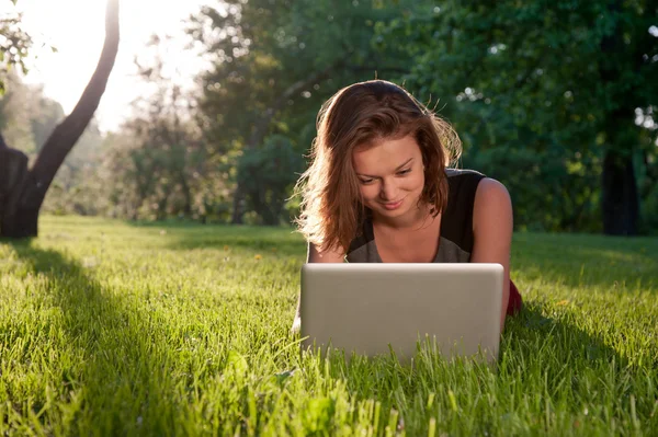 Donna con computer portatile sull'erba — Foto Stock