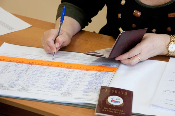 Vrouw namen van kiezers in de notebook van verkiezing schrijven Stockfoto