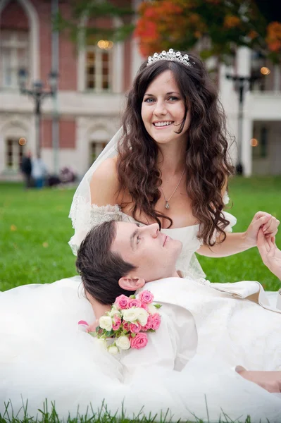 Mariée et fiancée se relaxant sur une herbe — Photo