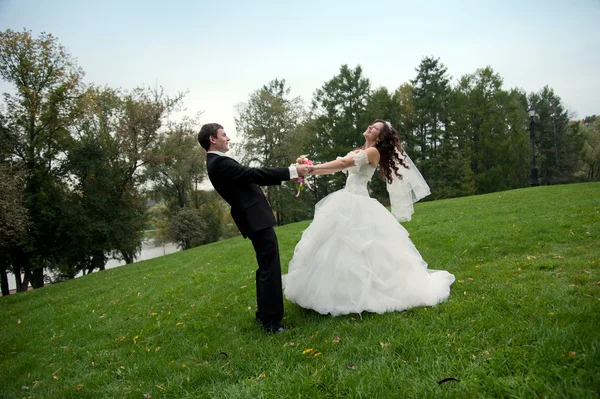 Pareja recién casada bailando en el campo — Foto de Stock