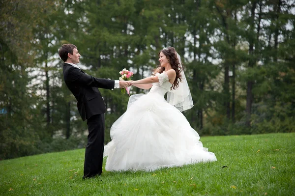 Pareja recién casada bailando en el campo — Foto de Stock