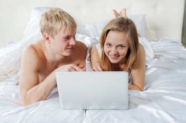 kız ve oğlan laptop ile yatakta yatan