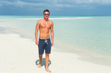 insan mavi deniz ve güzel gökyüzü ile sahilde yürüyor.