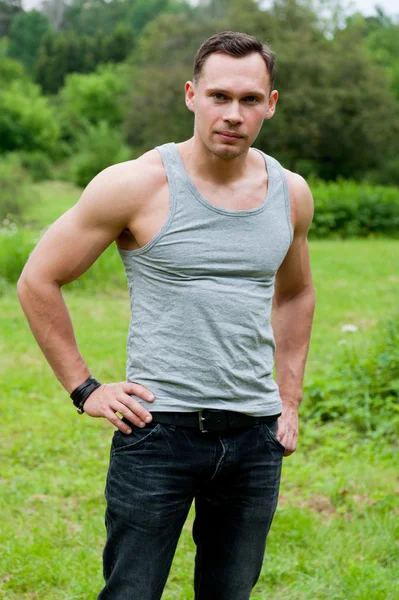 Man in een t-shirt staat op het gras — Stockfoto