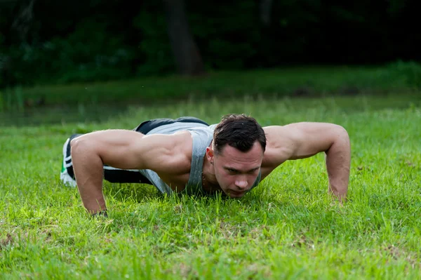 Uomo che fa esercizio di fitness sull'erba — Foto Stock