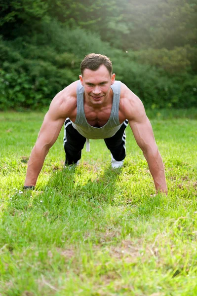 Man doen fitness oefening op het gras — Stockfoto