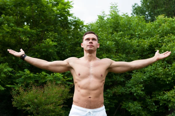 Man with a naked torso stands with his hands up — Stock Photo, Image