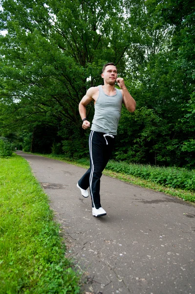 Man in black pants runs on the road — Stock Photo, Image