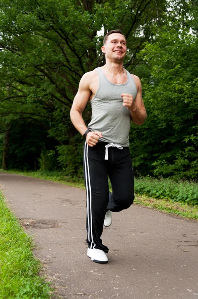 Man in black pants runs on the road — Stock Photo, Image