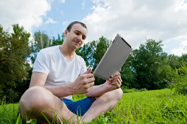 通过使用 tablet pc 在公园里的男人 — 图库照片