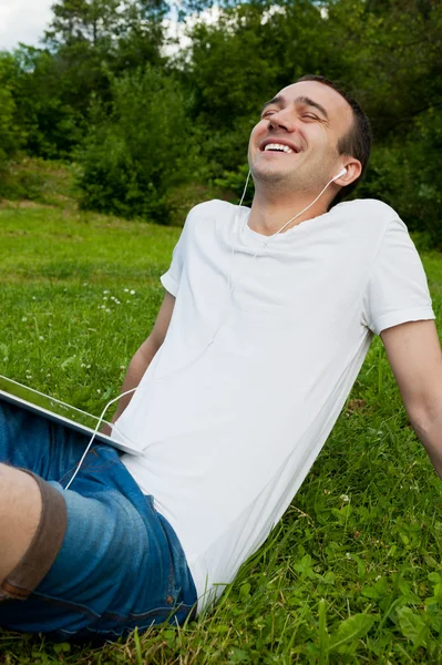 Jonge man luisteren naar muziek op hoofdtelefoon — Stockfoto