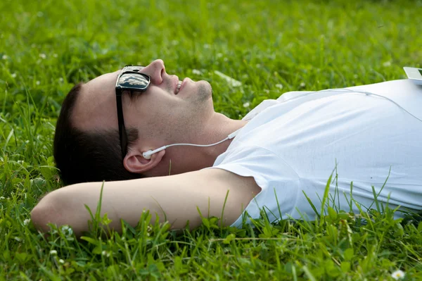 Joven escuchando música en los auriculares — Foto de Stock