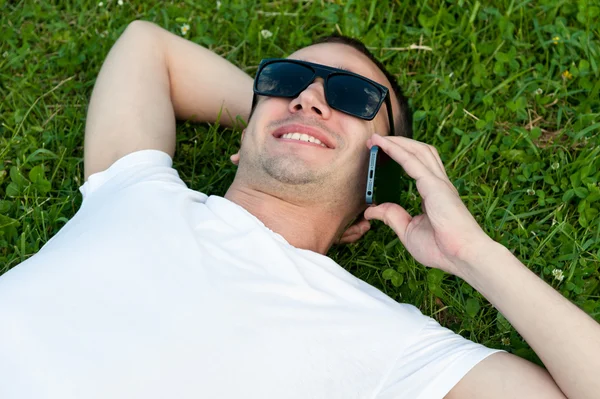 Lächelnder junger Mann, der mit dem Handy spricht — Stockfoto