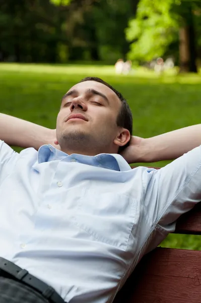 Man sitting on the bench with closing eyes — Stock Photo, Image