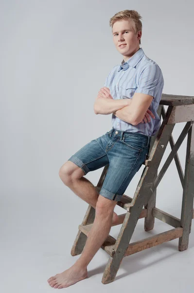 Young man stands near the ladder — Stock Photo, Image