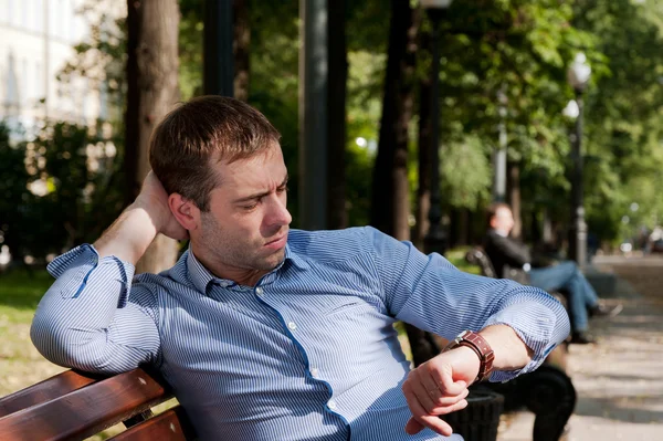 Hombre comprobando la hora en el jardín público — Foto de Stock