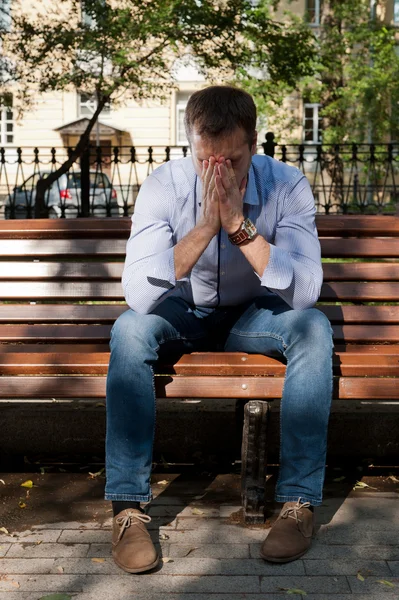 Man sits in the public garden — Stock Photo, Image