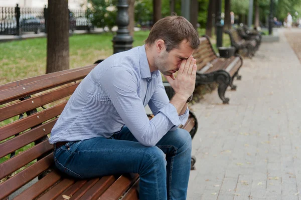 Man sits in the public garden — Stock Photo, Image