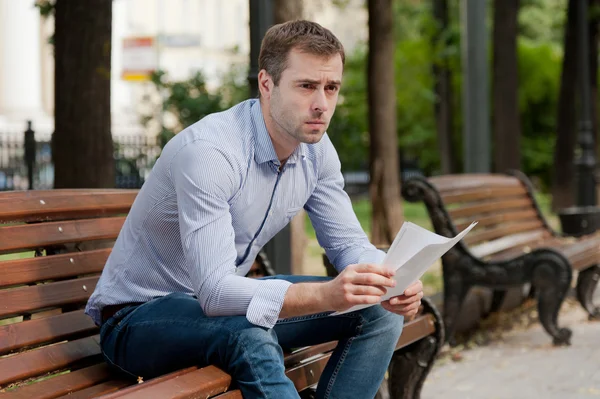 Hombre leyendo documentos en el jardín público — Foto de Stock