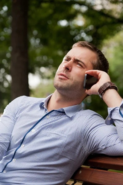 Man talking on the phone in the public garden — Stock Photo, Image