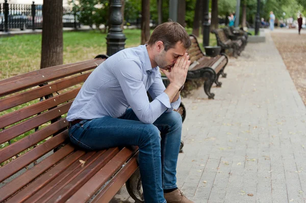 Man sits in the public garden — Stock Photo, Image