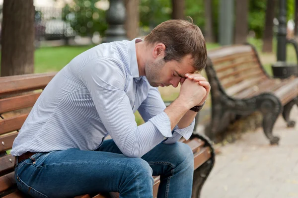 Man sits in the public garden — Stock Photo, Image