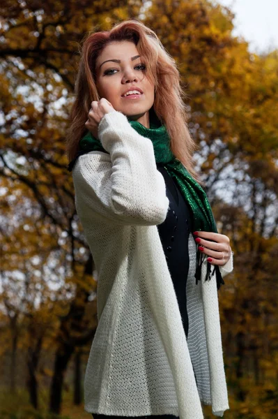 Güzel bir kadın beyaz kazaklı parkta yürüyor — Stok fotoğraf