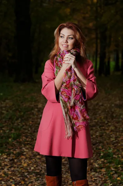 Bella donna in cappotto rosa passeggiate nel parco — Foto Stock