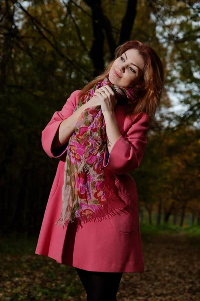 Beautiful woman in pink coat walks in the Park — Stock Photo, Image