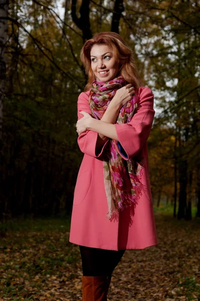 Bella donna in cappotto rosa passeggiate nel parco — Foto Stock