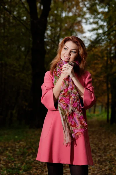 Pink paltolu güzel kadın parkta yürüyor — Stok fotoğraf