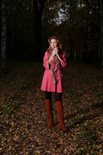 Belle femme en manteau rose marche dans le parc — Photo