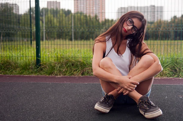 Портрет молодой женщины в очках на детской площадке — стоковое фото