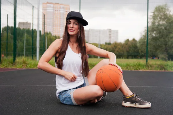 Sexy žena v ruce drží basketbal — Stock fotografie