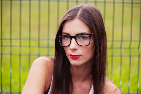 Retrato de mujer joven con gafas en el patio de recreo — Foto de Stock