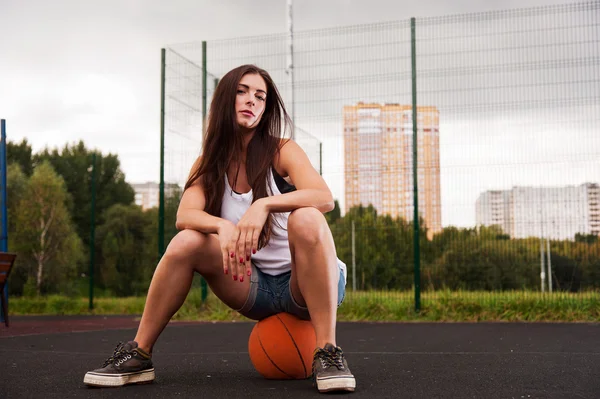 Sexy žena, sedící na basketbal — Stock fotografie