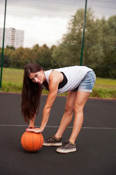 Sexy žena v ruce drží basketbal — Stock fotografie