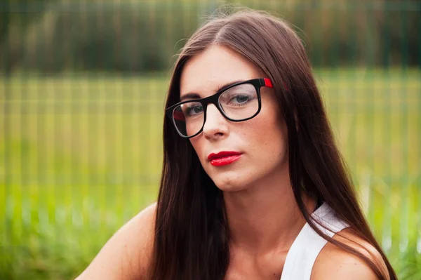 Retrato de mulher jovem vestindo óculos no parque infantil — Fotografia de Stock