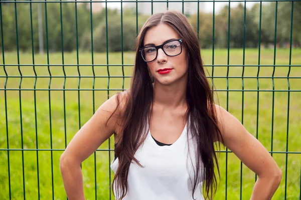 Retrato de mulher jovem vestindo óculos no parque infantil — Fotografia de Stock