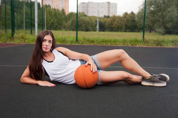 Красивая очаровательная женщина держит баскетбол в руке — стоковое фото